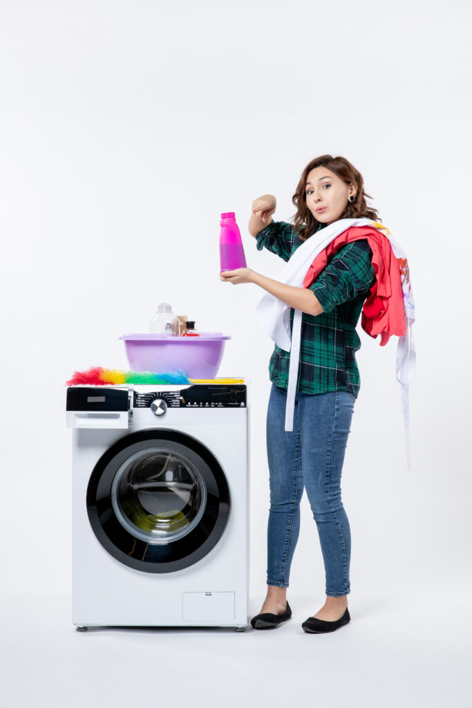 front view young female with washing machine preparing clothes white wall